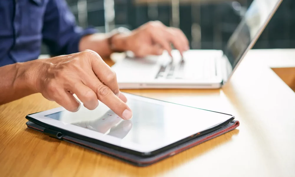 Businessman using application on tablet computer when working in office
