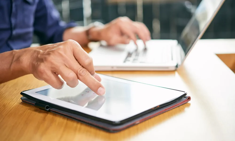 Businessman using application on tablet computer when working in office